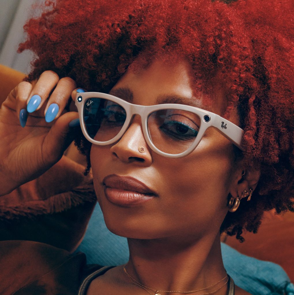 blog-turismax-modelo-de-cabelo-vermelho-usando-os-óculos-ray-ban-da-meta-com-foco-no-rosto-e-close-no-dispositivo