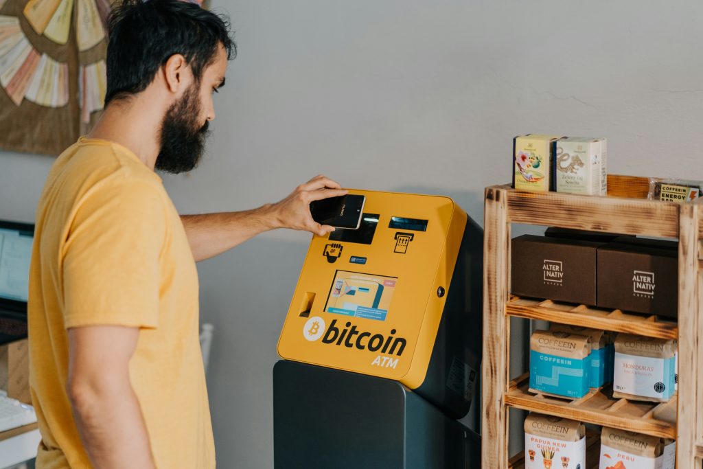homem-comprando-bitcoin-com-celular-usando-caixa-eletronica-BATMTwo-em-Praga